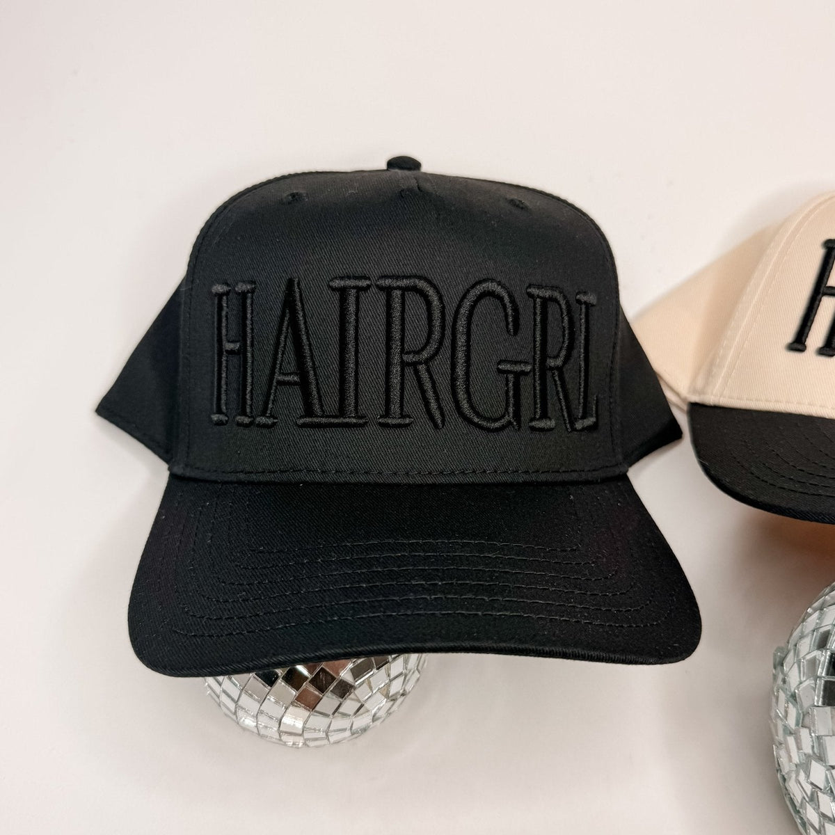 Black cap with 'HAIRGRI' text on a light background